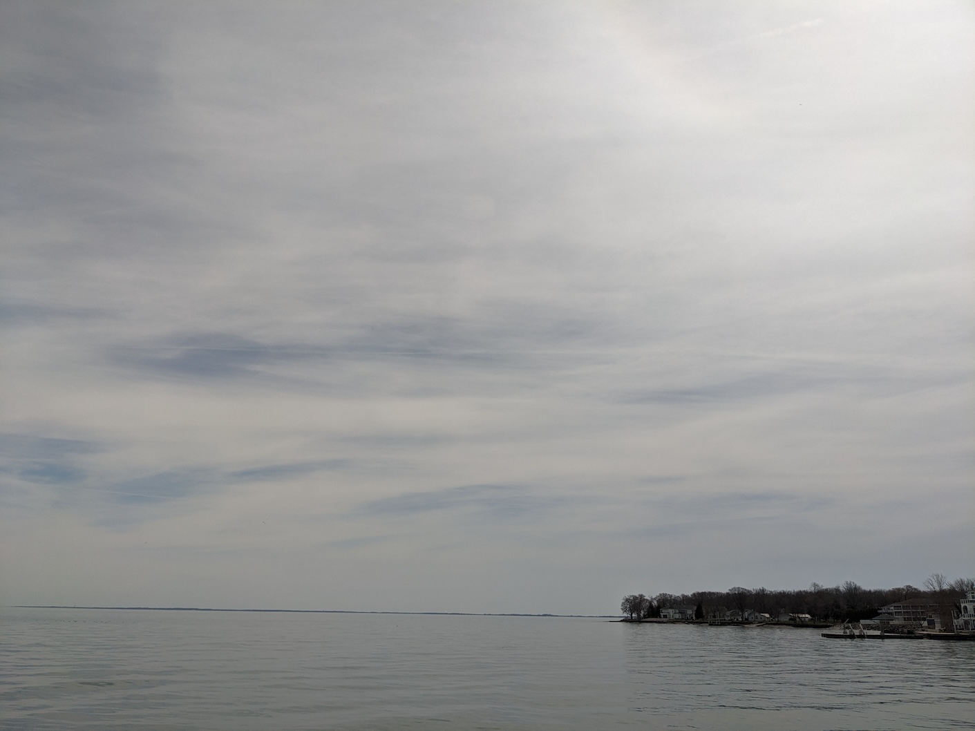 Lake Erie, gentle waves, darkening sky, bright sunlight glowing in the sky